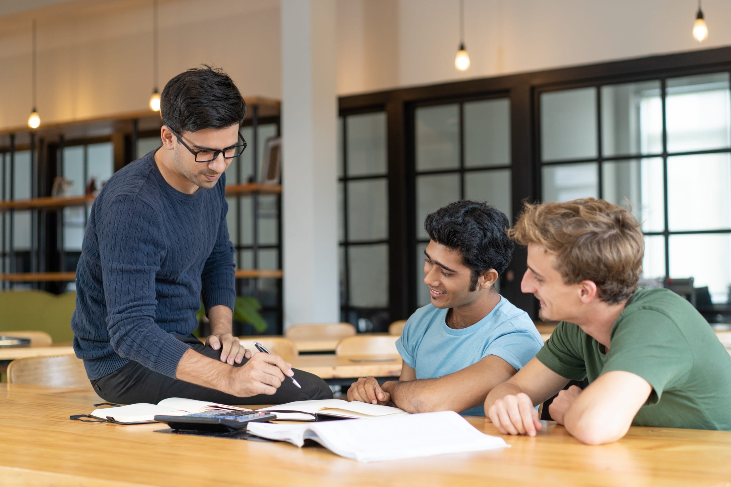 serious teacher checking assignment two students scaled